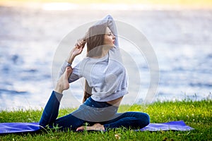 Beautiful sporty young woman working out on riverbank