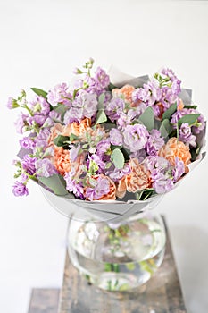 Beautiful spring bouquet. flowers arrangement with various of colors in glass vase on old table. bright room
