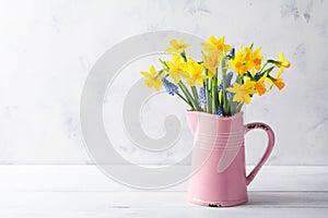 Beautiful spring composition with daffodil flowers in vase on white background. Woman day holiday greeting card