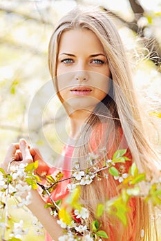 Beautiful spring girl in blooming garden