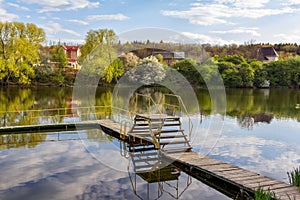 Beautiful spring landscape with calm river, wooden bridge