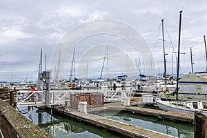 a beautiful spring landscape at Fisherman\'s Wharf on Pier 39 with boats and yachts docked in the harbor with ocean water