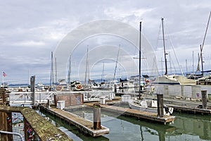 a beautiful spring landscape at Fisherman\'s Wharf on Pier 39 with boats and yachts docked in the harbor with ocean water