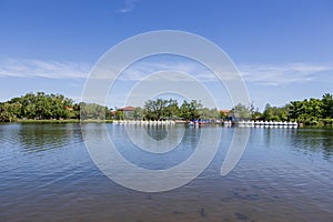 A beautiful spring landscape at New Orleans City Park with people, lush green trees, grass and plants, a lake, birds and blue sky