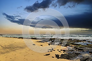 a beautiful spring landscape at Sandy Beach with blue ocean water, silky brown sand, rocks covered in green algae, crashing waves