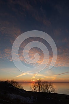 A beautiful spring sunset over the Baltic Sea with colorful skies and calm water.