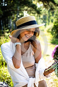 Beautiful spring woman portrait. Woman in a straw hat and a bouquet of flowers