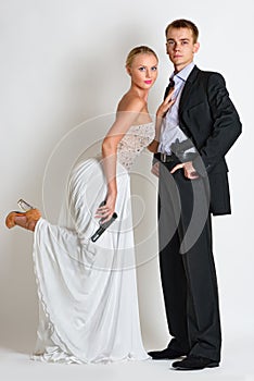 Beautiful spy couple in evening dress with a guns.