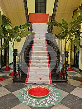 A Beautiful stairs covered with white sari with red border for bengalu wedding.