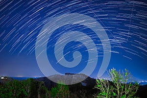 Beautiful star trails passing through hills and forest