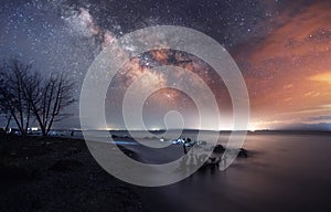 Beautiful starry sky with bright milky way galaxy over the lake. Night landscape .