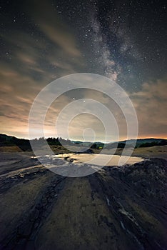 Beautiful starry sky with the Milky Way galaxy and a volcano crater in the foreground