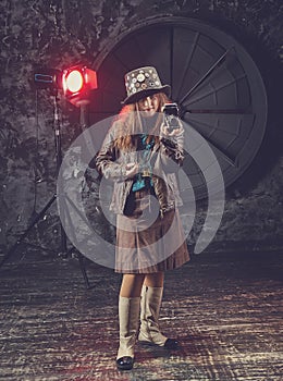 Beautiful steampunk teen girl  in goggles with old camera