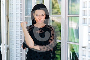 A beautiful, stern, dissatisfied woman looks at her interlocutor with disapproval, she is unhappy with his behavior. The