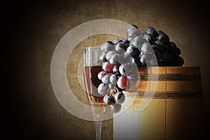 Beautiful still life with glass of red wine against background of oak wine barrel with red wine