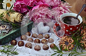 Beautiful still life with peony flowers, runes, book and tea cup in the garden