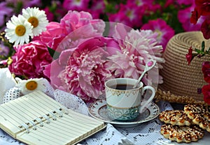 Beautiful still life with peony flowers, vintage cup and cookies on the table.