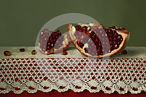 beautiful still life with pomegranate on a table with lace photo