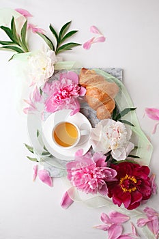 Beautiful still life with tea cup and peonies.Top view, summer french breakfast of bloger, feminine holiday morning concept