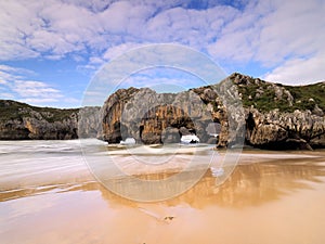 Beautiful stone arches on Playa de las Cuevas del Mar, Cantabria, Spain photo