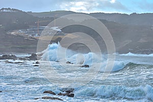 Beautiful stormy sea with the rocky cliffs in the background captured on a cloudy evening