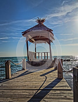 A beautiful straw hut in the sea lighted by the summer sun.