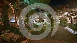 Beautiful street decorations with restaurant garlands in summer. Action. Beautiful garlands decorate garden courtyard of