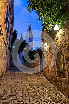 beautiful street of Rovinj Croatia with cobblestone and church tower dusk