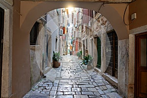 beautiful street of Rovinj Croatia with cobblestone looking through an arch tunel photo