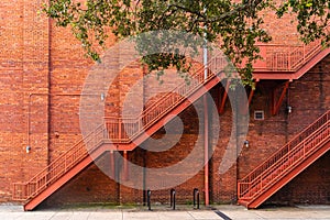 Beautiful streets and homes in downtown Savannah, two red metal stairs on a red brick wall, Georgia, USA