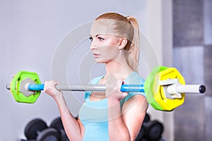 Beautiful strong blond woman with barbell