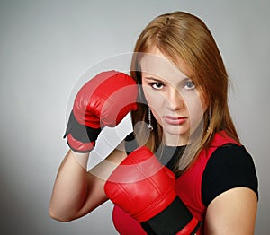 Beautiful strong girl in red gloves for boxing