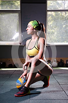 Beautiful, strong, slender, in good physical shape in the gym doing exercises. Dressed in short shorts and tank top green, . Sport