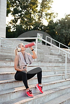 Beautiful strong young sports woman drinking water