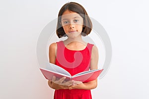 Beautiful student child girl reading red book standing over isolated white background with a confident expression on smart face
