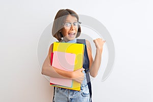 Beautiful student child girl wearing backpack glasses books over isolated white background pointing and showing with thumb up to