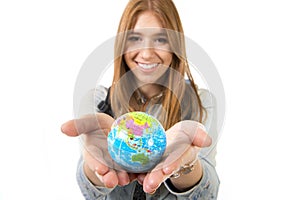 Beautiful student girl holding little world globe in her hand choosing holidays destination in travel tourism concept