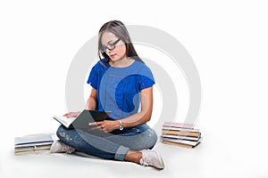 Beautiful student girl sitting on blanket and studying