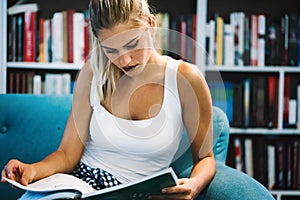 Beautiful student girl studying, reading book at home