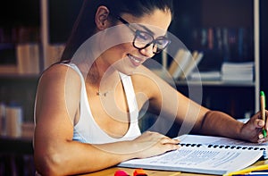 Beautiful student girl studying, reading book at home