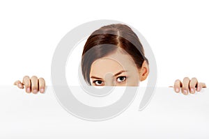 Beautiful student woman hiding her face behind blank banner