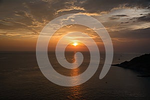 Beautiful, stunning panoramic view of the golden sky and reflections on the Andaman sea during the sunset at Promthep Cape