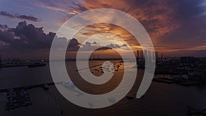 Beautiful, stunning sunset over the water, over boats in an industrial looking dock or port.