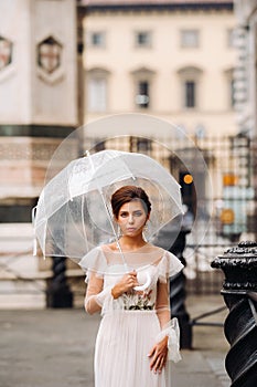 A beautiful stylish bride with an umbrella walks through the old city of Florence.Model with umbrellas in Italy.Tuscany