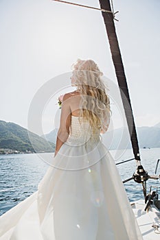 Beautiful stylish bride in a white wedding dress on luxury yacht