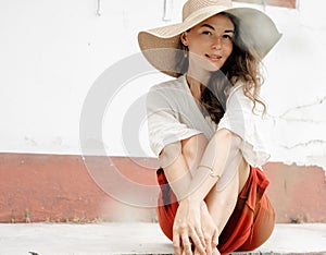 Beautiful stylish elegant fashionable young brunette woman in a hat, looking at the camera, beauty and fashion