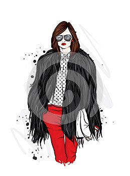 Beautiful stylish girl in a fur coat, trousers and glasses. Fashionable clothes and accessories. Fashion