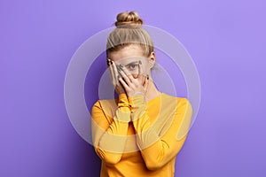 Beautiful stylish girl hiding herself behind palms.