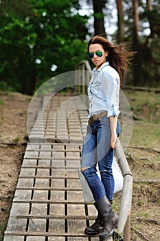 Beautiful stylish girl in jeans shirt and sunglasses - full length portrait