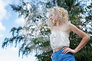 Beautiful stylish glamorous young blonde woman with curly hair enjoying spring and summer nature